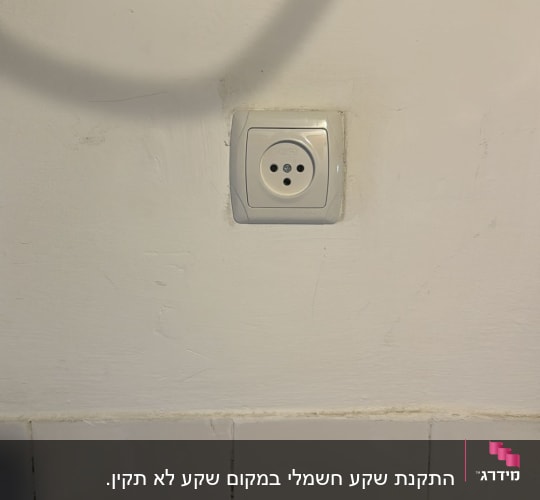 שקע חשמל בקיר לבן עם אריחים